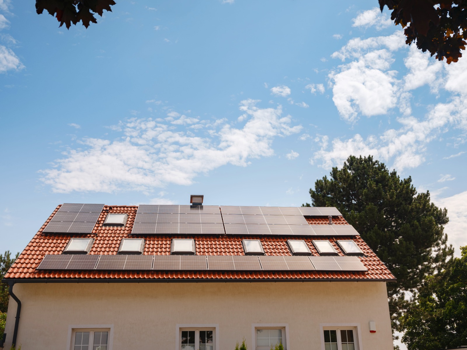 Fotovoltaické panely na střeše pod modrou oblohou